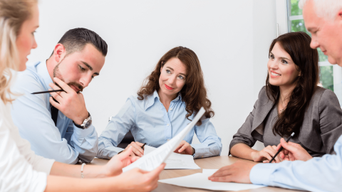 Professionals around a table to represent how to start your own law firm.