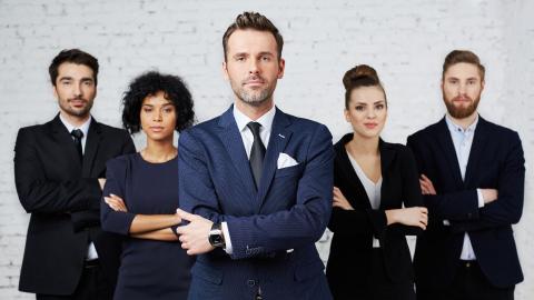 5 individuals from the legal profession, formally dressed, standing in a row with their arms crossed in front of them